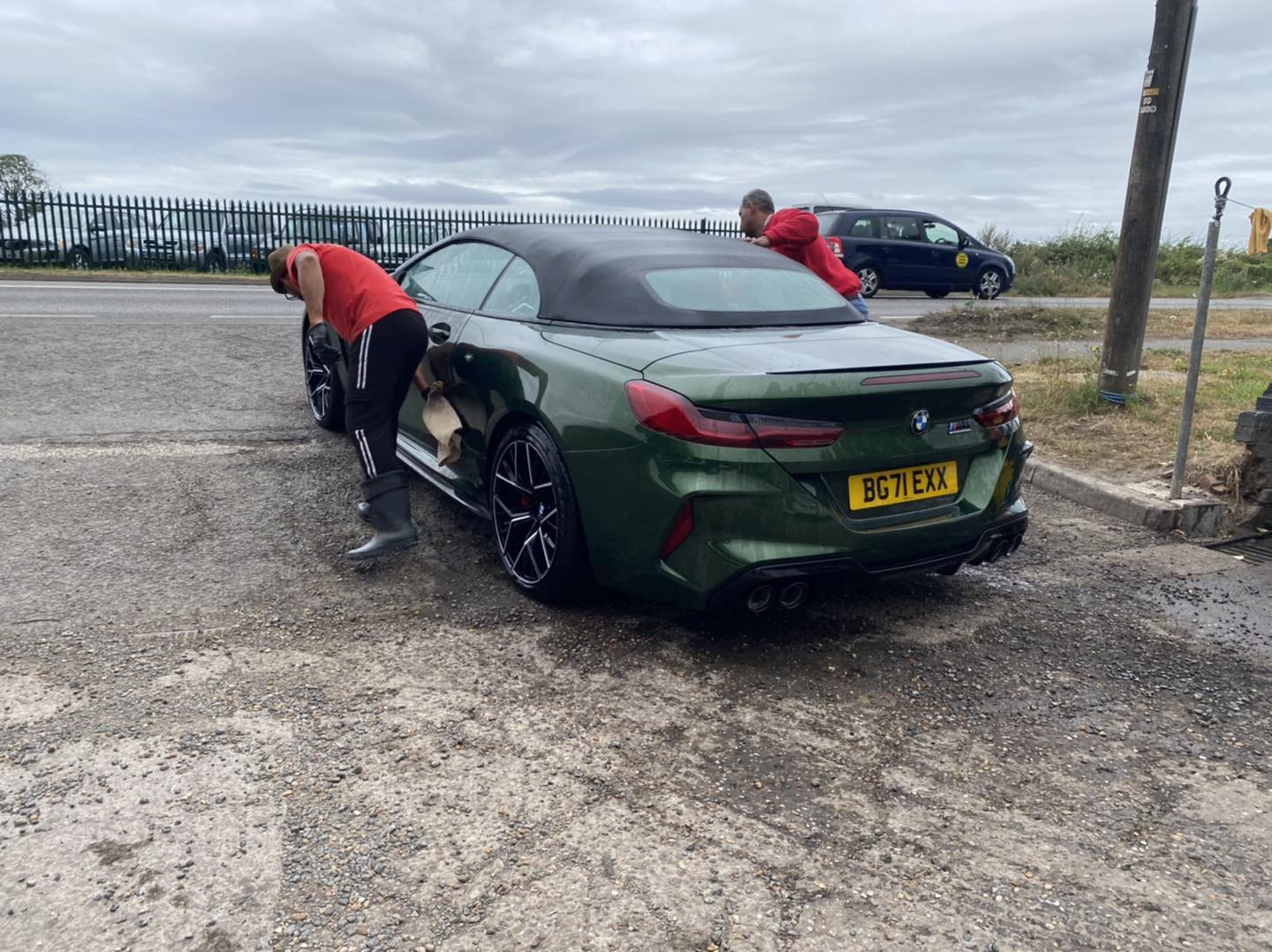Bubbleboyz team hand-finishing a green BMW convertible